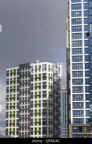 Costruzione di edifici a più piani. Moderno edificio a più piani. Case costruite in cemento e vetro. Foto Stock