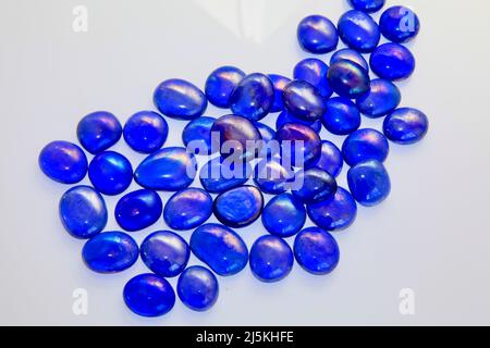 Palline di vetro blu su sfondo bianco Aprile 2022 Foto Stock