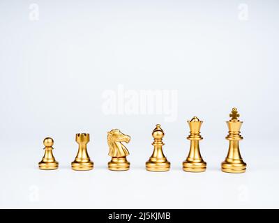 Set di scacchi dorati di lusso isolati su sfondo bianco. La foto di scacchi d'oro, re, rook, vescovo, regina, cavaliere, e pedina. Foto Stock