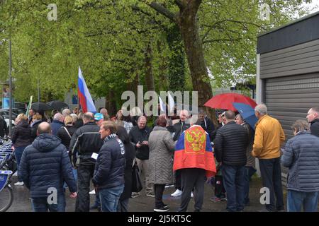 Lahr, Germania. 24th Apr 2022. La gente si raduna con le bandiere russe prima dell'inizio di un raduno pro-russo attraverso la Lahr, dove vivono migliaia di tedeschi etnici dell'ex Unione Sovietica. Circa 100 persone si sono radunate alla stazione ferroviaria della città nel distretto di Ortenau, secondo un portavoce della polizia. Secondo gli organizzatori, la protesta è stata diretta contro "la criminalità contro i tedeschi russi, per la pace, contro la guerra”. Credit: Maren Richter/Thomas Reichelt/dpa/Alamy Live News Foto Stock