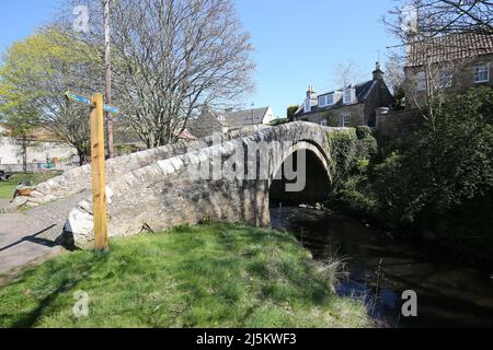 Ceres, Fife, Scotland, UK. Situato in una piccola glen, a circa 2 miglia sopra il Ceres Moor da Cupar e a 7 miglia da St Andrews. L'ex parrocchia di questo nome includeva gli insediamenti di Baldinnie, Chance Inn, Craigrothie, Pitscottie e Tarvit Mill. E' anche la sede del Museo Folcloristico di Fife. Il Ceres Burn si estende lungo le Bow Butts e il verde del villaggio e si estende lungo l'attraente ponte del 17th secolo, noto anche come "Ponte del Vescovo". Foto Stock