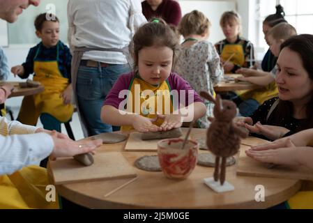 Varsavia, Polonia, Polonia. 24th Apr 2022. I bambini prendono parte ad un laboratorio di argilla il 24 aprile 2022 a Varsavia, in Polonia. Alcune decine di ucraini e polacchi hanno partecipato ad un pranzo di Pasqua di integrazione organizzato dal produttore polacco di ceramiche Cepiela (acronimo per la sede dell'industria folcloristica e artistica) e attivista del collettivo STUS in occasione della domenica di Pasqua ortodossa, Con l'obiettivo di integrare la comunità polacca e Ucraina a Varsavia, in Polonia. Un laboratorio di argilla per i bambini ha seguito il pranzo. (Credit Image: © Aleksander Kalka/ZUMA Press Wire) Foto Stock