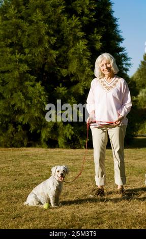 Donna anziana con il suo cane Cockapoo anziano Foto Stock