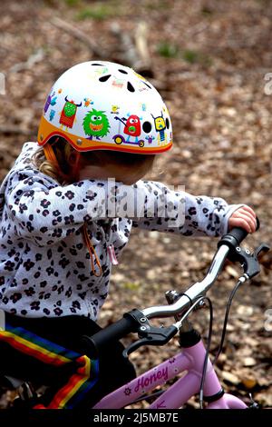 ragazza di 3 anni sulla sua moto, piangendo. REGNO UNITO Foto Stock