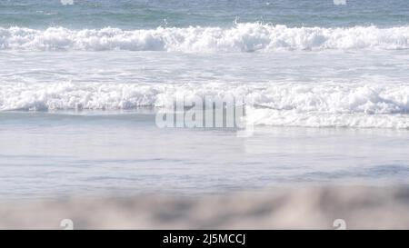 Le grandi onde blu dell'oceano si infrangono sulla spiaggia, la costa pacifica della California, gli Stati Uniti. Schiuma di acqua di mare e sabbia bianca. Estate estetica a terra. Surf vibes, stagcape vicino a Los Angeles. Cinematografia senza giunture. Foto Stock