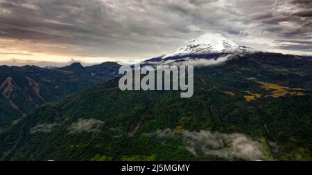 Vulcano Antisana in Ecuador, vista dal villaggio di Papallacta, neve sulla cima e foreste verdi intorno, paesaggio fotografia, stratovulcano. Foto Stock