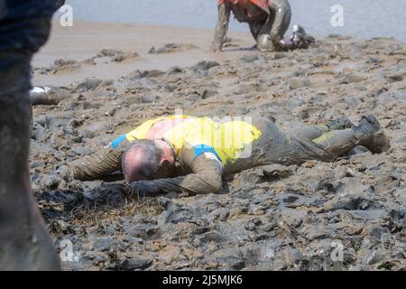 Un concorrente che si posa in fango partecipa alla Maldon Mud Race di Maldon, Essex, mentre la gara ritorna per la prima volta in due anni. La Maldon Mud Race è una gara di divertimento annuale che si tiene in primavera (originariamente in inverno, ora a fine aprile o all'inizio di maggio) al Promenade Park di Maldon, Essex, in Inghilterra, in cui i partecipanti competono per completare un trattino di 500 metri (550 yd), in fango denso, Sul letto del fiume Blackwater. La gara è organizzata dai Lions & Rotary Club del Maldon e del Maldon District Council, che raccoglie denaro per beneficenza. Foto Stock
