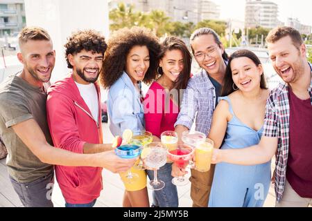 I giovani Happy People bevono cocktail sul tetto. Gruppo di amici che scattano foto in una festa e si divertono Foto Stock