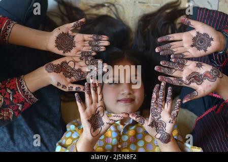 Lahore, Punjab, Pakistan. 24th Apr 2022. Le ragazze pakistane hanno  decorazioni all'henné applicate sulle loro mani a casa loro per il prossimo  festival musulmano di Eid al-Fitr a Lahore. I musulmani di