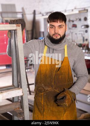 Fabbro in officina di lavorazione dei metalli Foto Stock