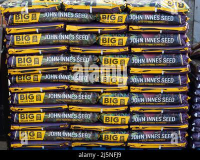 Una pila di 35 litri grandi borse di valore di John Innes seme semina compost per la vendita in un negozio di fattoria Foto Stock