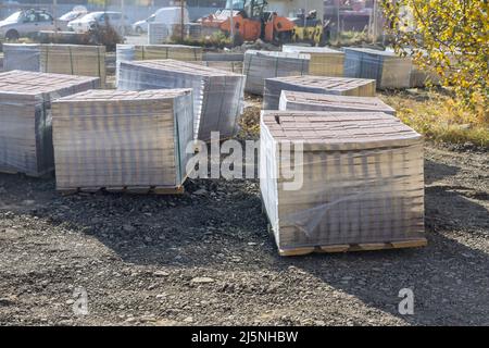 Riparazione pavimentazione posa lastre di pavimentazione su passerella la pila di pietre di pavimentazione in calcestruzzo Foto Stock