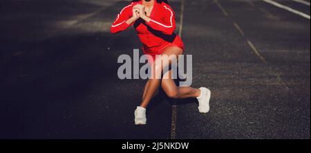 Giovane donna runner con bella figura facendo esercizio stretching. Stile di vita sano Foto Stock