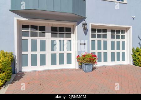 Porte da garage doppie con pannelli in vetro e blu chiaro con telai a griglia bianchi a San Francisco, CA Foto Stock