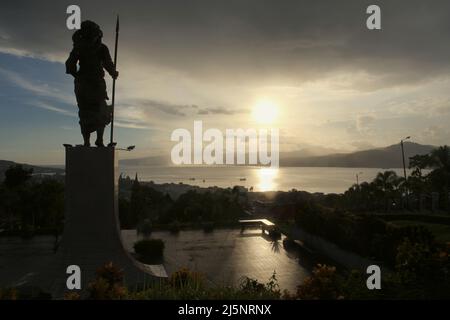 Silhouette della statua di 8 metri di Martha Christina Tiahhu (1800-1818), un'eroina conosciuta per il suo ruolo durante le battaglie contro il sovrano coloniale nel 19th secolo. Il monumento si trova sulla collina di Karangpanjang che domina la città di Ambon, la baia di Ambon e il mare di banda nel centro di Maluku, Maluku, Indonesia. Foto Stock