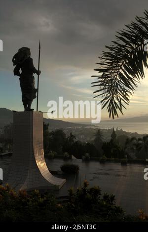 Silhouette della statua di 8 metri di Martha Christina Tiahhu (1800-1818), un'eroina conosciuta per il suo ruolo durante le battaglie contro il sovrano coloniale nel 19th secolo. Il monumento si trova sulla collina di Karangpanjang che domina la città di Ambon, la baia di Ambon e il mare di banda nel centro di Maluku, Maluku, Indonesia. Foto Stock