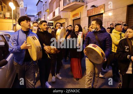 25 aprile 2022, Pagani, Campania/Salerno, Italia: Ragazzi e ragazze nel centro storico, all'alba. All'alba di lunedì i tammorrari, già impegnati per tre giorni e notti a suonare e ballare nei toselli, vanno in processione al santuario, dove depositano i loro strumenti ai piedi della Vergine e, ringraziandola, fanno un atto di sottomissione, Poi, senza mai voltere le spalle sull'altare, lascia il santuario cantando l'antica canzone popolare Madonna de la Grazia. Al termine delle celebrazioni di Santa Maria incoronata del Carmine, chiamata 'Madonna delle Galli Foto Stock