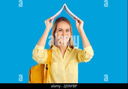 Studentessa sorridente con libro e zaino Foto Stock