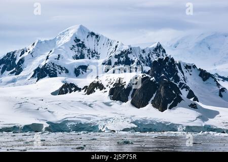 Montagne innevate e ghiacciate e ghiacciaio dell'isola di Petermann, Antartide Foto Stock