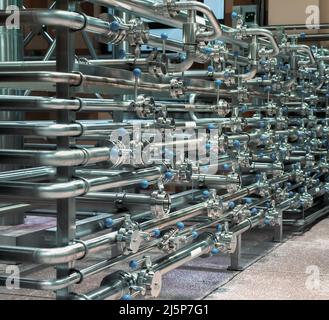 Sistema di tubi in acciaio in impianti per la lavorazione di alimenti e bevande. Condutture in fabbrica di birra. Foto Stock