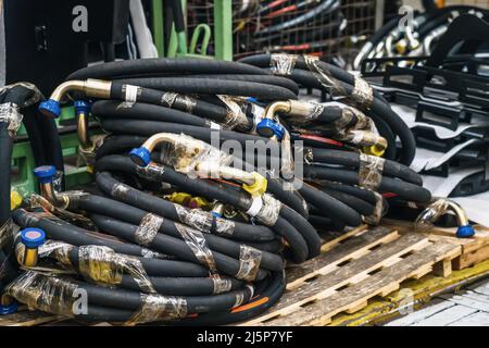 Fasci di tubi flessibili in gomma nera a stock in fabbrica. Foto Stock