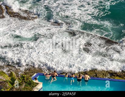 Persone in una piscina a sfioro guardando l'oceano al Condado Vanderbilt Hotel a San Juan Foto Stock