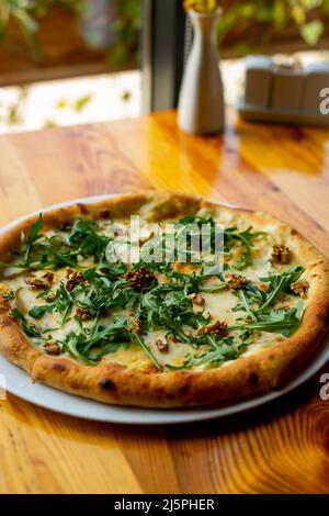 Deliziosa pizza al formaggio vegeteriano con noci e basilico fondo tavola in legno, primo piano. Luogo per il testo Foto Stock