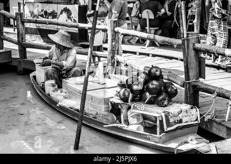 Pattaya, Thailandia - 6 dicembre 2009: Venditore in barca al mercato galleggiante di Pattaya che vende latte di cocco. Fotografia in bianco e nero Foto Stock