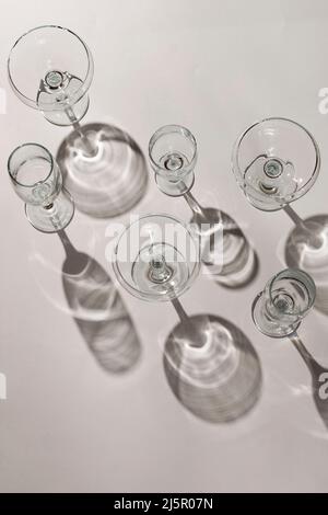 Bicchieri da cocktail con lunghe ombre sul tavolo Foto Stock