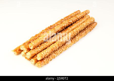 Pila di bastoncini di grano con semi di sesamo idolati su sfondo bianco Foto Stock