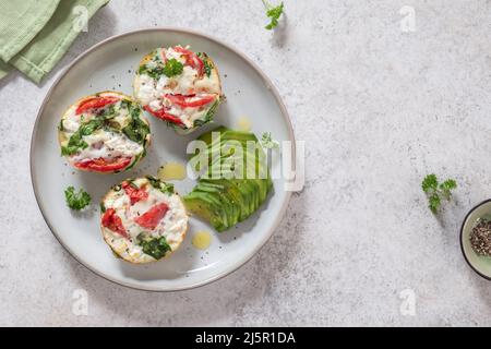 Muffin all'uovo con pomodoro, spinaci e formaggio Foto Stock