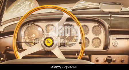ESSEN, GERMANIA - 23 MARZO 2022: Stile retrò iamge degli interni di una classica vettura sportiva Ferrari con volante in legno ad Essen, Germania Foto Stock