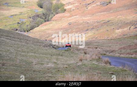 La ripida strada dell'Hardknott Pass, uno dei ripidi passi di Lakeland che seguirà il Fred Whitton Challenge. Questa è una delle molte strade del Lake District, Cumbria, Inghilterra, Regno Unito, sarà chiusa il 8th maggio 2022, quando 2.500 ciclisti percorreranno il percorso Fred Whitton Challenge. Fred Whitton Challenge è un evento benefico cyclosportive che si tiene annualmente nel Lake District inglese. Si tiene in memoria di Fred Whitton, segretario di corse del Lakes Road Club, morto di cancro all'età di 50 anni nel 1998. Foto Stock