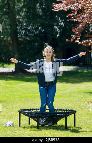 Una ragazza sta saltando su un trampolino per mostrare lo strenghth delle molle. Foto Stock