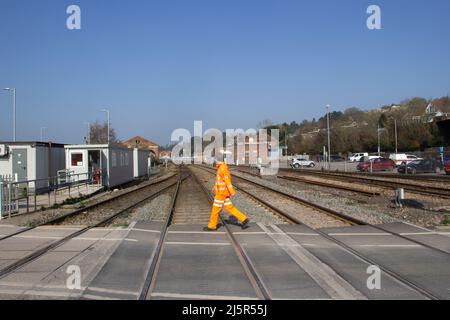 EXETER, UK - 1 MARZO 2021 uomo che attraversa l'incrocio Red Cow alla stazione ferroviaria di Exeter St David Foto Stock