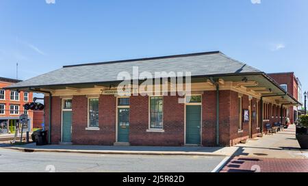 MOORESVILLE, NC, USA-17 APRILE 2022: Lo storico deposito dei treni di Mooresville su Main Street. Giorno soleggiato, cielo blu. Foto Stock