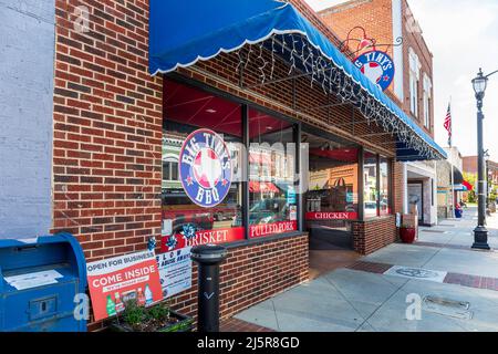 MOORESVILLE, NC, USA-17 APRILE 2022: Barbecue Big Tiny's. Prospettiva diagonale della parte anteriore del negozio, con vista dal basso del marciapiede. Foto Stock