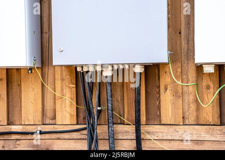 quadri elettrici e cavi elettrici collegati a loro sulla parete Foto Stock