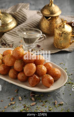 luqaimat o lokma. Lokma fritto di fresco (luqma - arabic) impaccato alto un dessert medio orientale popolare di palle di pasta fritte profonde poi rivestite in sug Foto Stock