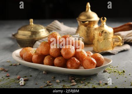 luqaimat o lokma. Lokma fritto di fresco (luqma - arabic) impaccato alto un dessert medio orientale popolare di palle di pasta fritte profonde poi rivestite in sug Foto Stock