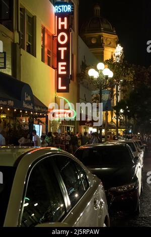 Foto notturna del cartello al neon illuminato Astor Hotel e della vivace atmosfera intorno a e St, Gaslamp Quarter, San Diego Foto Stock