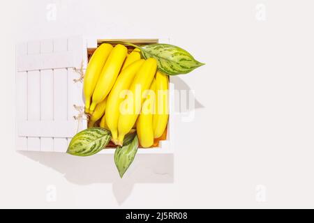 Mele verdi fresche con foglie in una scatola di legno su sfondo bianco. Frutta sana di stagione con un sacco di vitamine. Confezionamento di frutta eco-friendly e s Foto Stock