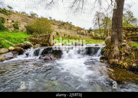 Torrente d'acqua che scende dalla montagna nel grazioso villaggio di Hervas, Caceres. Foto Stock
