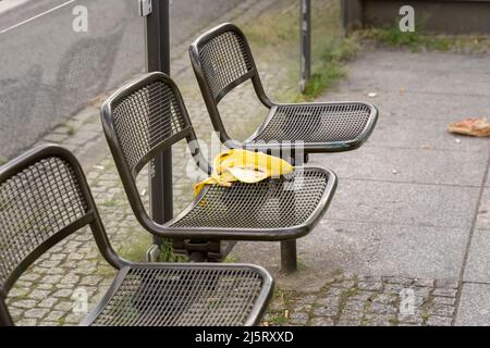 Scorza di banana su un posto a sedere alla fermata dell'autobus. Inquinamento in una zona urbana. Posto sporco in un'area pubblica in un rifugio per autobus. Rifiuti organici che giacciono intorno. Foto Stock