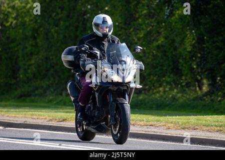 Uomo a cavallo di una moto nera Triumph Tiger Foto Stock