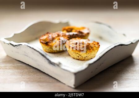 Tre muffin di cupcake pasquali fatti in casa appena sfornati su vassoio vintage di legno bianco sullo sfondo del tavolo Foto Stock