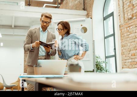 Il capo maschile del team sta esaminando i risultati del lavoro di squadra Foto Stock