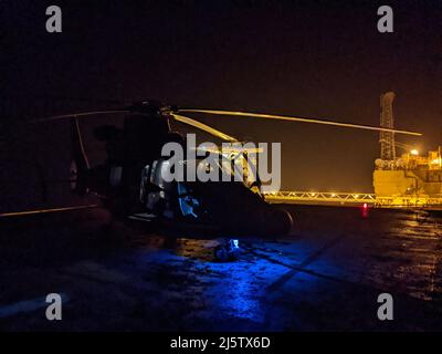 A Coast Guard Air Station Houston MH-65 l'equipaggio di elicotteri Dolphin medevacs un uomo di 68 anni da una nave cuise circa 160 miglia a sud-est di Galveston, Texas, 25 aprile 2022. L'uomo, che stava sperimentando reportly il dolore alla schiena severo, la pressione sanguigna bassa e la frequenza cardiaca diminuita, è stato trasportato alla filiale medica dell'università del Texas a Galveston in condizione stabile. (STATI UNITI Foto della Guardia Costiera, cortesia Air Station Houston) Foto Stock