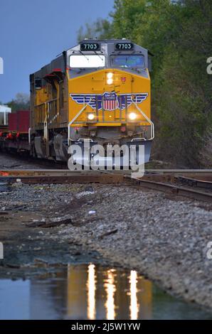 Elgin, Illinois, Stati Uniti. Attraversa le locomotive Union Pacific Railroad e guida un treno merci Canadian National Railway attraverso una traversata di diamanti. Foto Stock