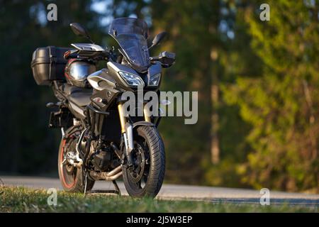 Un moto parcheggio sulla strada sul lato destro e al tramonto, selezionare sfondo di focalizzazione. Foto Stock